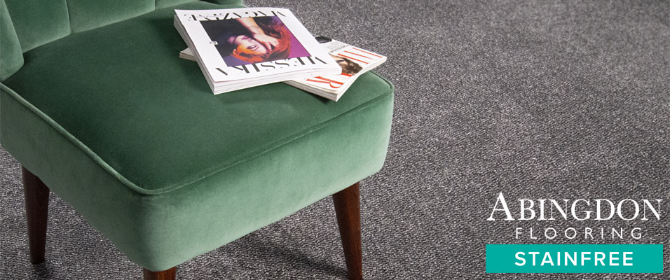 A charcoal coloured, tweed style carpet with a green velvet chair, an easy care, atmospheric carpet.